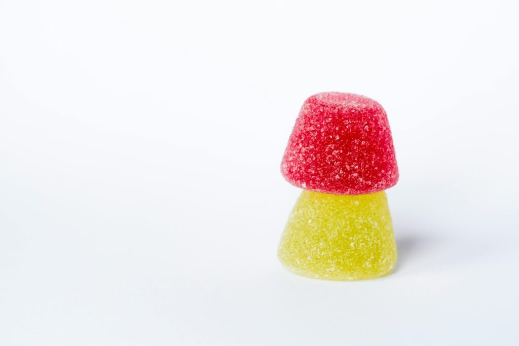 Close-up of red and yellow sugar-coated gummies on a white background.